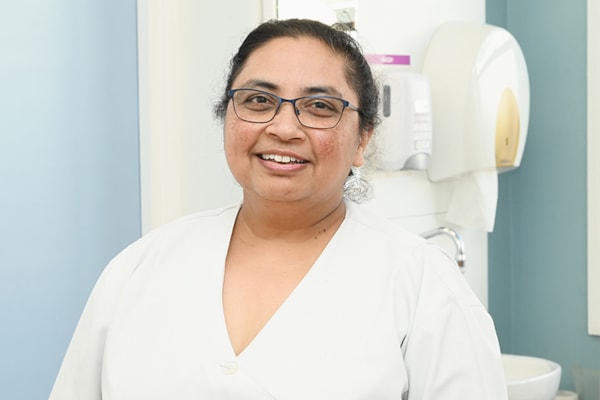 Female nurse in a clinical setting smiling at the camera